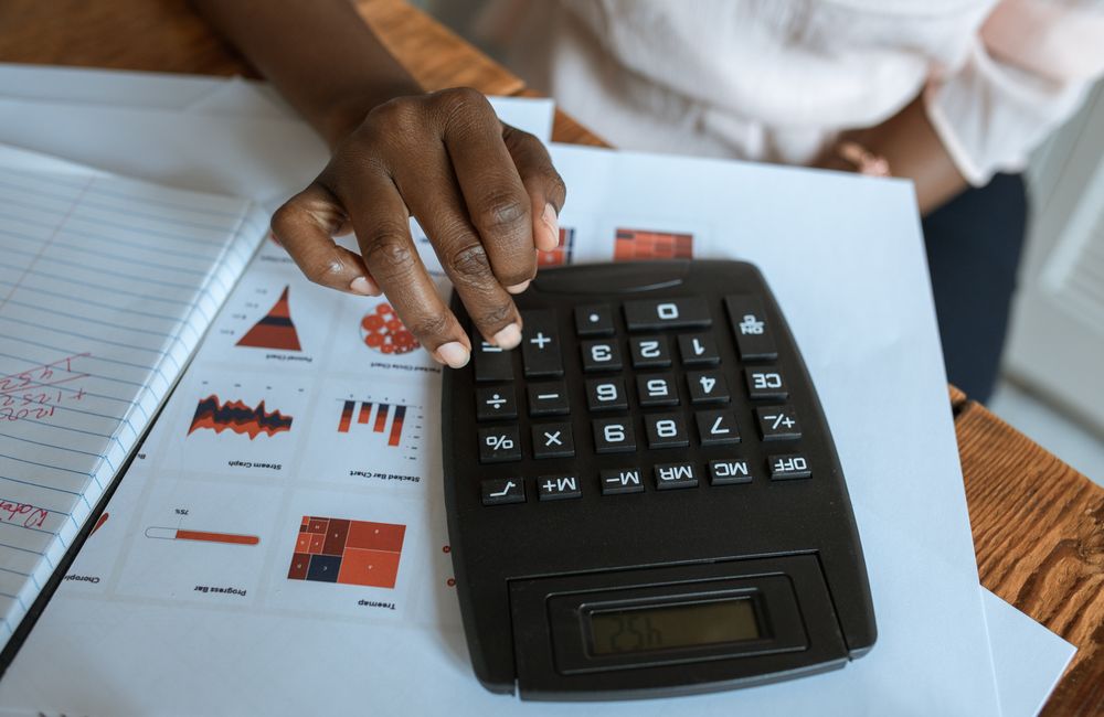 Calculator and financial paperwork on a desk.