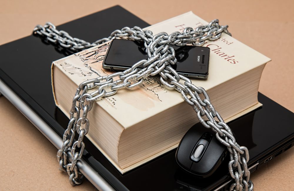 Devices and a notebook secured with a chain and padlock.